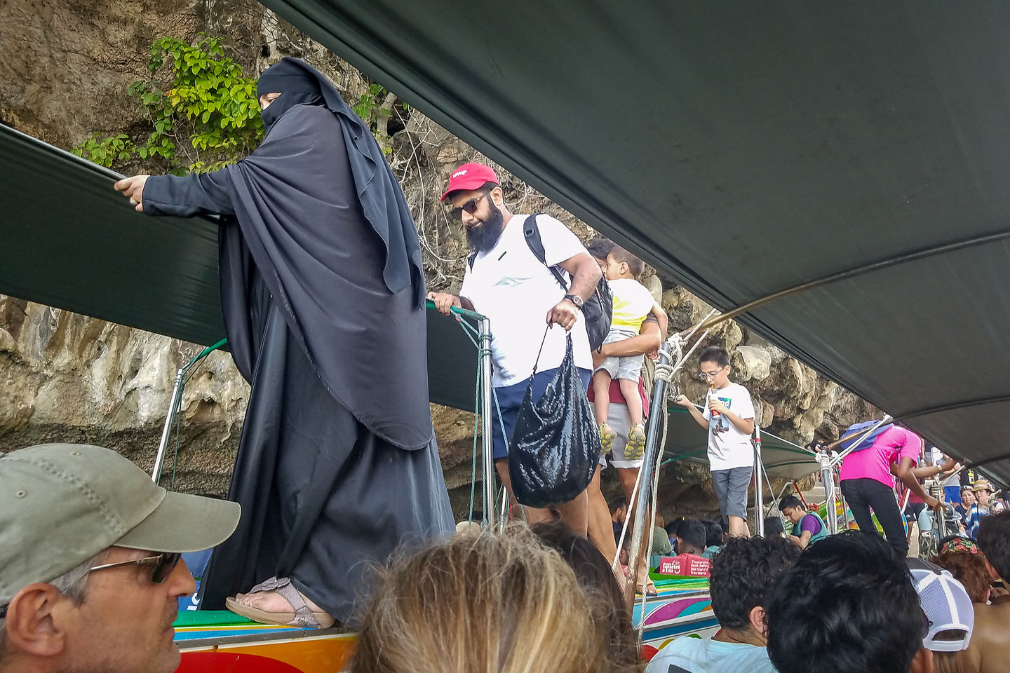 Precarious disembarking of long-tail boat onto James Bond Island