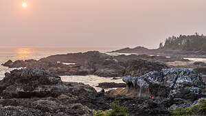 Lolo scrambling over the sharp rocks to get the shot